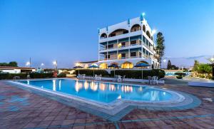 a hotel with a swimming pool in front of a building at Hotel Tsagarakis Beach in Amoudara Herakliou