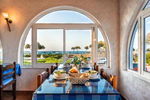 a dining room with a table with a view of the ocean at Hotel Tsagarakis Beach in Amoudara Herakliou