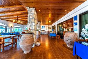 a restaurant with large vases in the middle of a room at Hotel Tsagarakis Beach in Amoudara Herakliou
