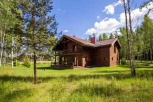 a wooden house in the middle of a field at Friends & Family Getaway to Forest House by Reside Baltic in Samaka