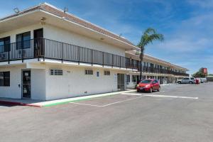 a building with a car parked in a parking lot at Econo Lodge Stockton near I-5 Fairgrounds in Stockton