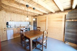 - une cuisine avec une table et des chaises en bois dans l'établissement Apartament Cal Josepó, à Ger