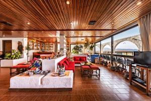 a living room with couches and tables and a tv at Hotel Tsagarakis Beach in Amoudara Herakliou