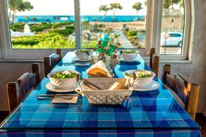 a table with a blue table cloth with a view of the ocean at Hotel Tsagarakis Beach in Amoudara Herakliou