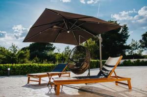 um par de cadeiras e um guarda-sol e um baloiço em Villa Vinko em Trogir