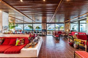 a large lobby with red couches and tables and windows at Hotel Tsagarakis Beach in Amoudara Herakliou