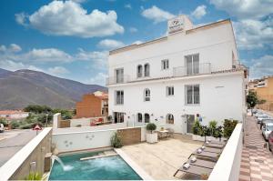 a hotel with a swimming pool and a building at Alpujarra Secret in Órgiva