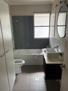 a bathroom with a sink and a toilet and a mirror at Reef Terraces on St Crispins in Port Douglas