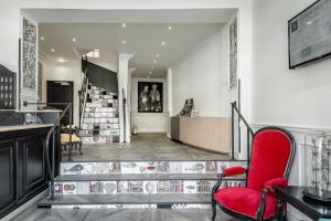 a lobby with a red chair and a staircase at The Originals Boutique, Grand Hôtel de la Gare, Toulon in Toulon