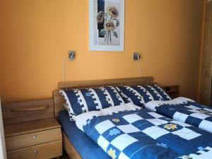 Schlafzimmer mit einem Bett mit blauer und weißer Decke in der Unterkunft Al Ponte 4 in Leukerbad