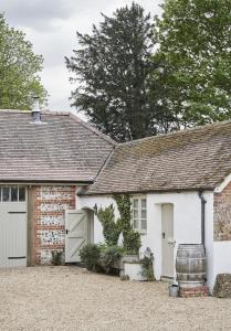 a brick house with a garage with a barrel outside at The Cottages at Launceston Farm in Blandford Forum