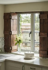 a kitchen with a window and a vase of flowers at The Cottages at Launceston Farm in Blandford Forum