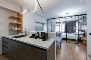 eine Küche mit einem Waschbecken und ein Zimmer mit einem Bett in der Unterkunft Ethereal Athεns in Athen