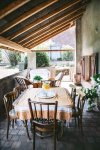 a wooden table and chairs on a patio at v i o l e t t e La souris des champs in Étival-Clairefontaine