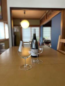 dos copas de vino sentadas sobre una mesa en Vacation house月yue, en Tokushima