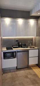 a kitchen with white cabinets and a sink and a microwave at Villy Luxury Home 2 in Ayiá