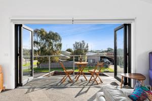 a living room with sliding glass doors and a table and chairs at Dundundra Villa in Clifton Springs