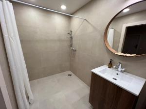 a bathroom with a sink and a shower with a mirror at Marių Banga in Nida