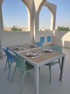 a wooden table with chairs and plates on it at Desert Path in Beʼer Ora