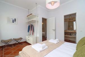 een slaapkamer met een bed en 2 handdoeken bij Casa do Terraço in São Martinho do Porto