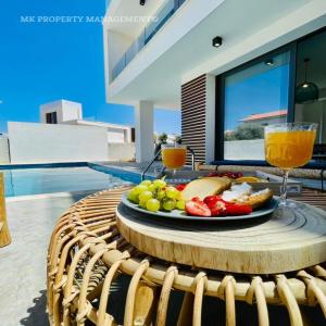 a plate of food on a table with a glass of orange juice at By the Beach Villa 7 in Protaras