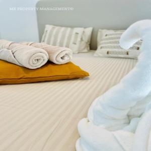 a white bed with towels on top of it at By the Beach Villa 7 in Protaras