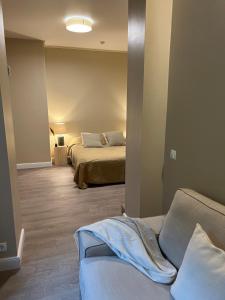 a room with two beds and a couch in it at Marių Banga in Nida