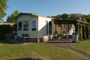 une petite maison avec une pergola et un patio dans l'établissement Chalet Regge, à Giethmen