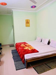 sypialnia z dużym łóżkiem i czerwonym kocem w obiekcie Anand Dham Guest House By WB Inn w mieście Sītāpur Mūāfi