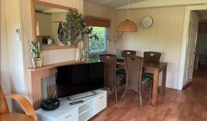 een eetkamer met een tafel en een televisie bij Chalet Regge in Giethmen