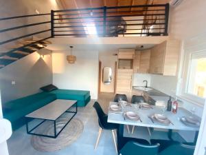 una pequeña sala de estar con una mesa y un sofá verde en Apartment house GAIA en Gajac