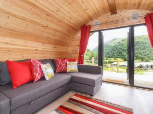 a living room with a gray couch with red pillows at Hartsop Magic - Crossgate Luxury Glamping in Penrith