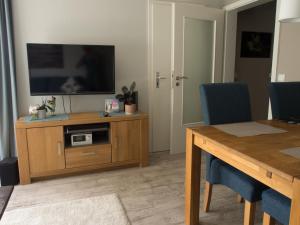 a living room with a television on a wooden entertainment center at FEWO Muschel in Glücksburg