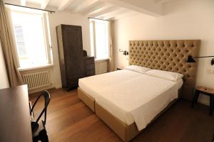 a bedroom with a large bed with a large headboard at Opera 11 r&b in Parma