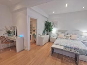 a white bedroom with a bed and a desk at Turquesa :) Parking and Wifi in Bilbao