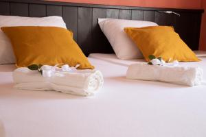 2 Handtücher auf einem Bett mit gelben Kissen in der Unterkunft Casa Palma in Alhaurín de la Torre