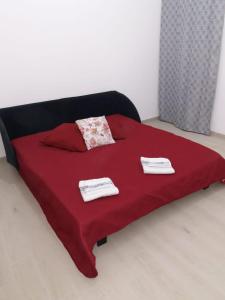 ein rotes Bett mit zwei Handtüchern darüber in der Unterkunft Casa The life in Trapani