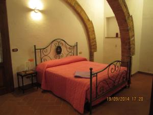 a bedroom with a bed with a red bedspread at La Civetta in Torrita di Siena