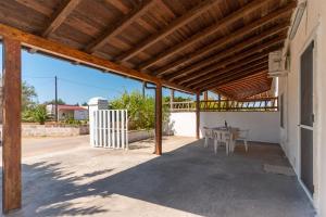 patio ze stołem i drewnianym dachem w obiekcie Casa Vacanze Salento w mieście Galatone