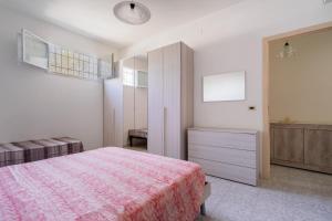 sypialnia z różowym łóżkiem, komodą i oknem w obiekcie Casa Vacanze Salento w mieście Galatone