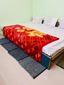 łóżko z czerwonym kocem na górze w obiekcie Anand Dham Guest House By WB Inn w mieście Sītāpur Mūāfi