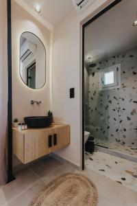 uma casa de banho com um lavatório e um espelho em Villa veranda em Plaka