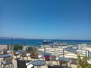 un patio con tavoli, sedie e un porto di Naxos Illusion Nikos Verikokos a Naxos Chora