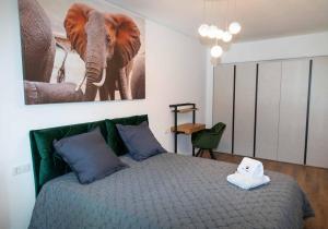 Un dormitorio con una cama con una foto de un elefante en BG LUXIMMO APARTMENTS en Cluj-Napoca