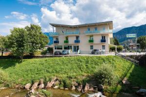 ein Gebäude mit einem Fluss davor in der Unterkunft Energy Hotel in Calceranica al Lago