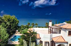 a house with a swimming pool in front of the ocean at Theos Club Villas in Polis Chrysochous