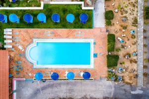 an overhead view of a swimming pool with blue umbrellas at Hotel Tsagarakis Beach in Amoudara Herakliou