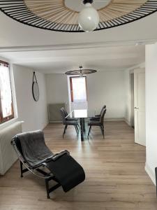 salon ze stołem i krzesłami oraz sufitem w obiekcie appartement le fil d'or w mieście Colmar