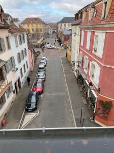 widok na ulicę z samochodami zaparkowanymi na ulicy w obiekcie appartement le fil d'or w mieście Colmar
