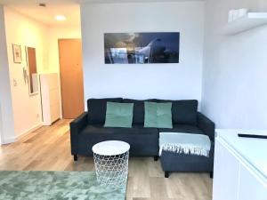 ein Wohnzimmer mit einem Sofa und einem Tisch in der Unterkunft Helles und ruhiges Apartment direkt am Flughafen Leipzig Halle in Schkeuditz